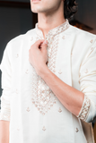 Cream silk kurta with embroidered golden motifs.